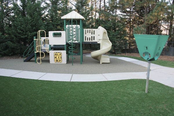 Playground with slides and climbing structures next to a walking path
