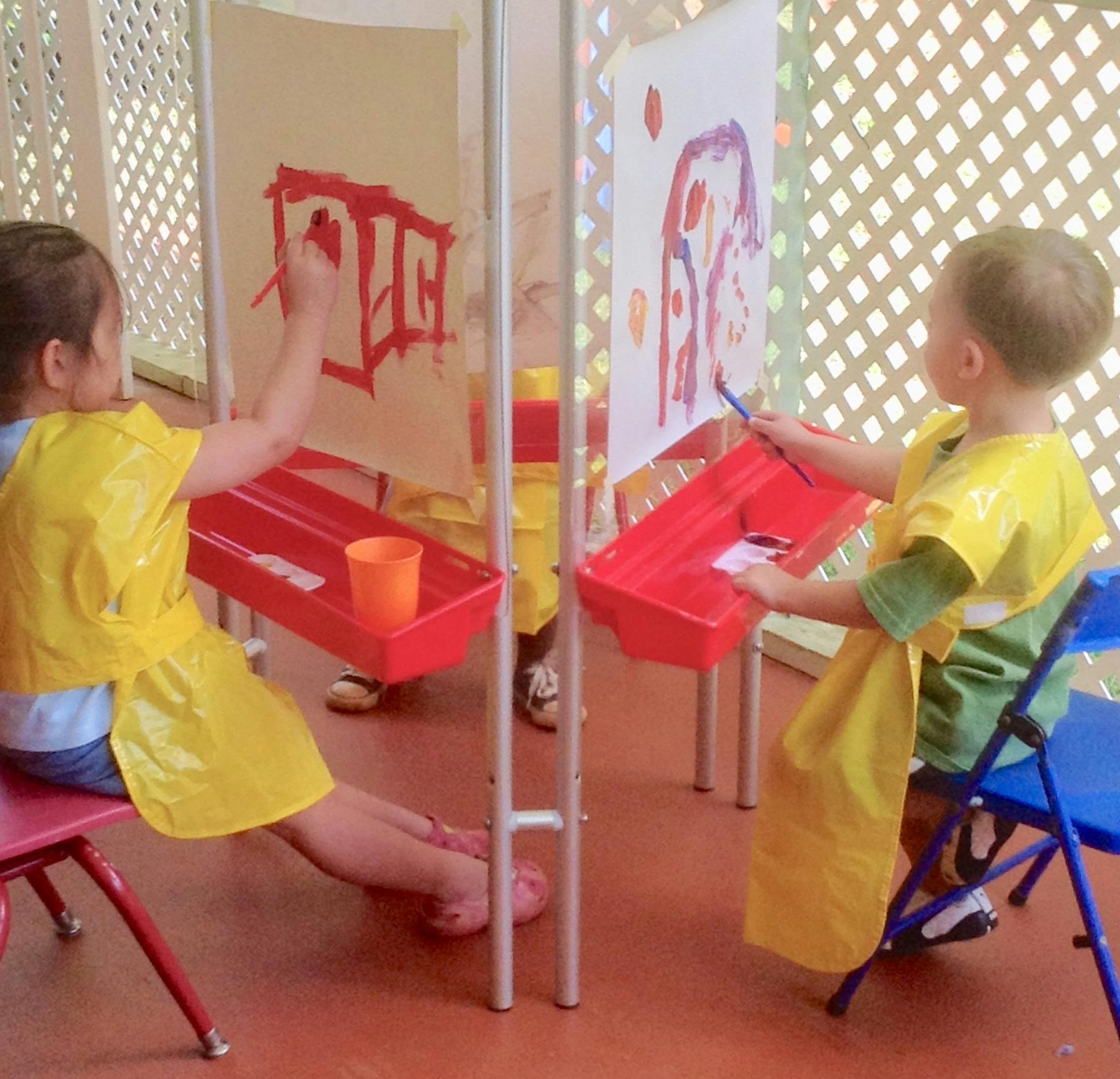 Two children painting at easels