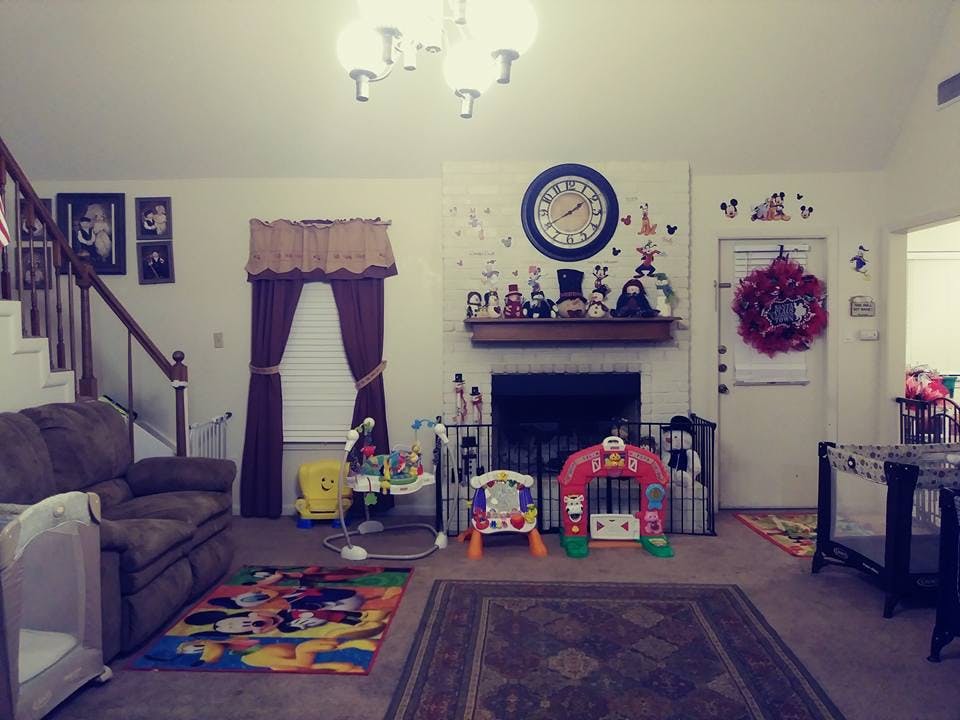 Living room with a sofa, fireplace, and child play items