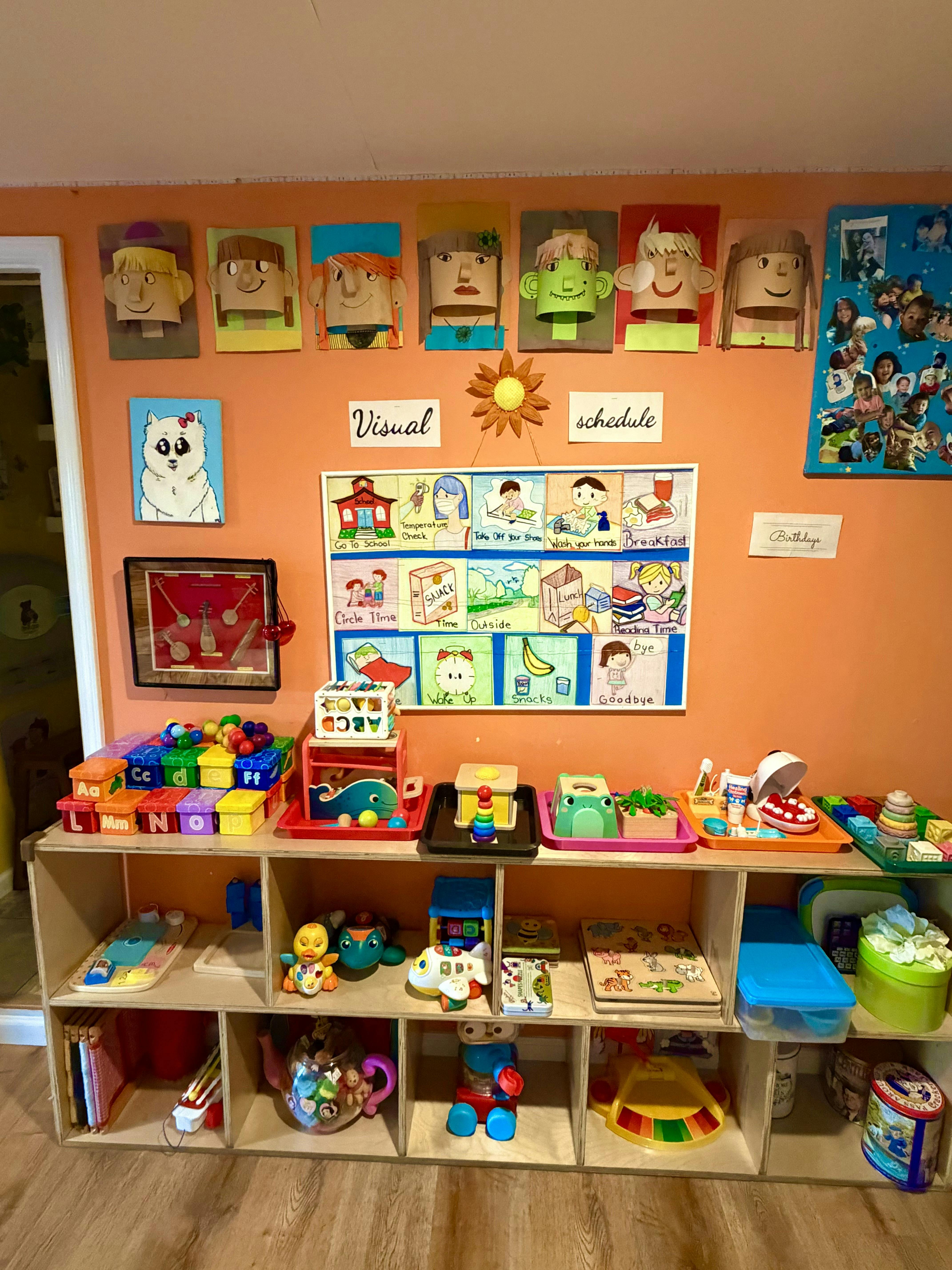 Children's classroom with visual schedule, art, and toys on shelves