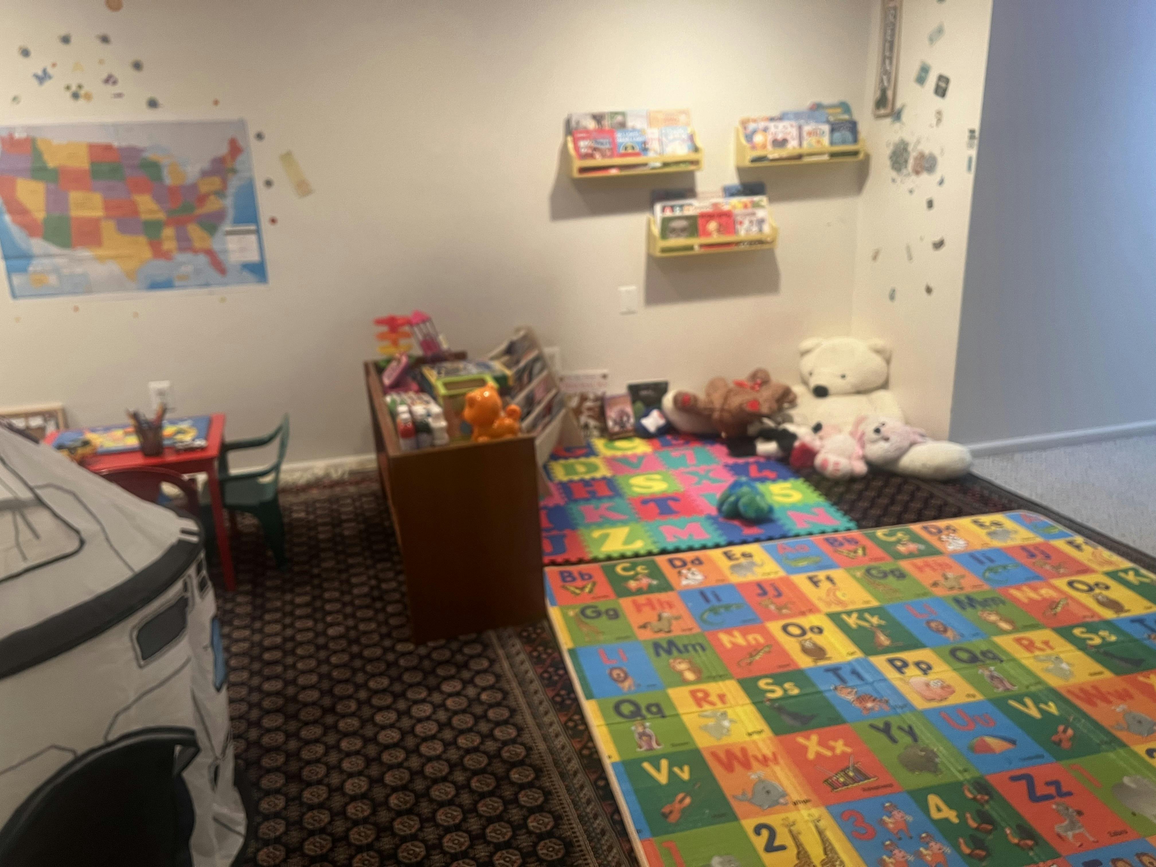 Playroom with alphabet mats, stuffed animals, and a US map on the wall