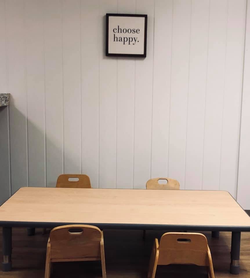Table with chairs and a framed sign that says "choose happy"