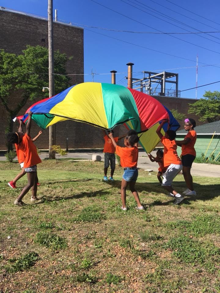 Children playing with a colorful parachute outdoors