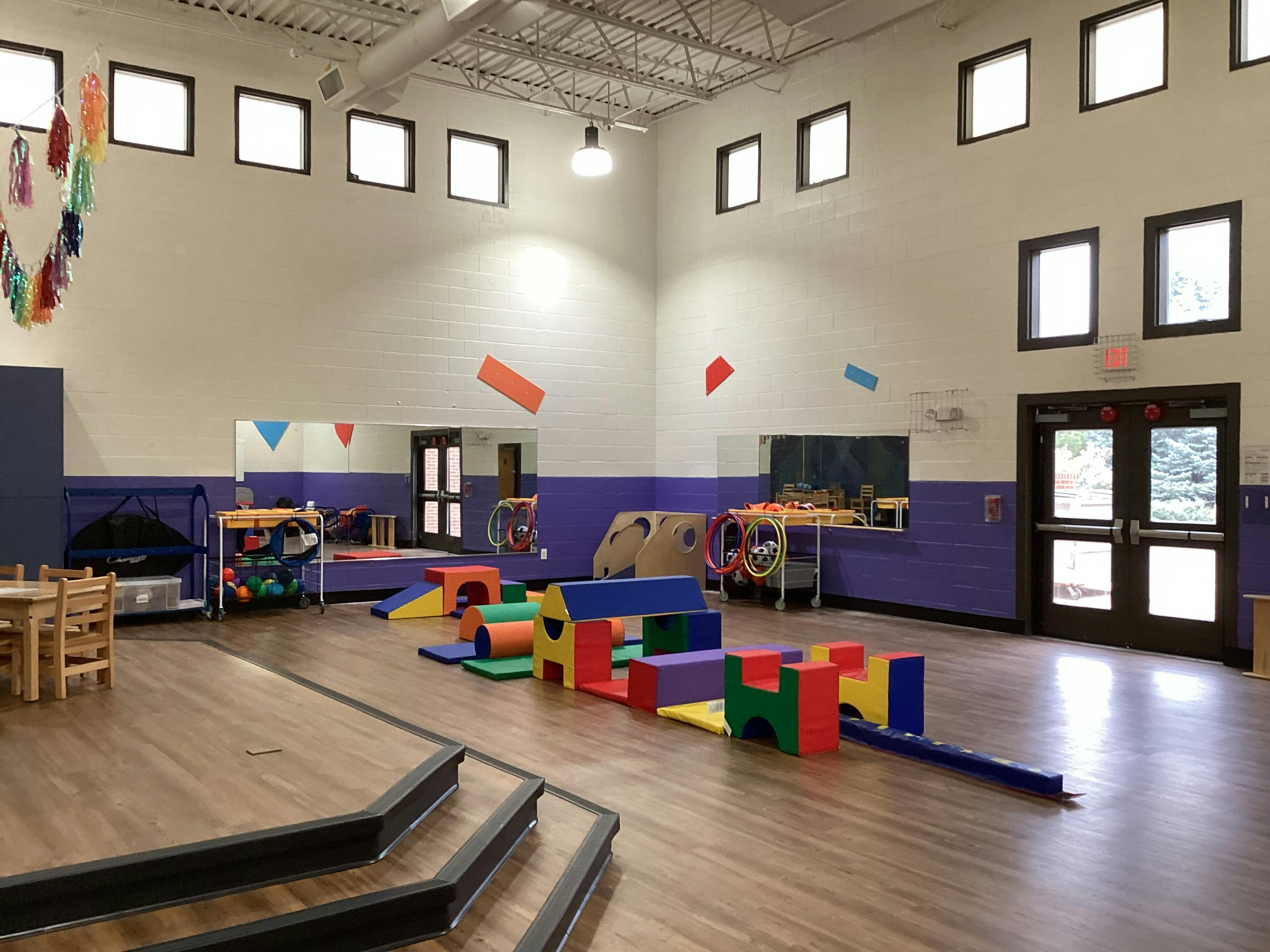 Colorful soft play equipment on a wooden floor in a large room