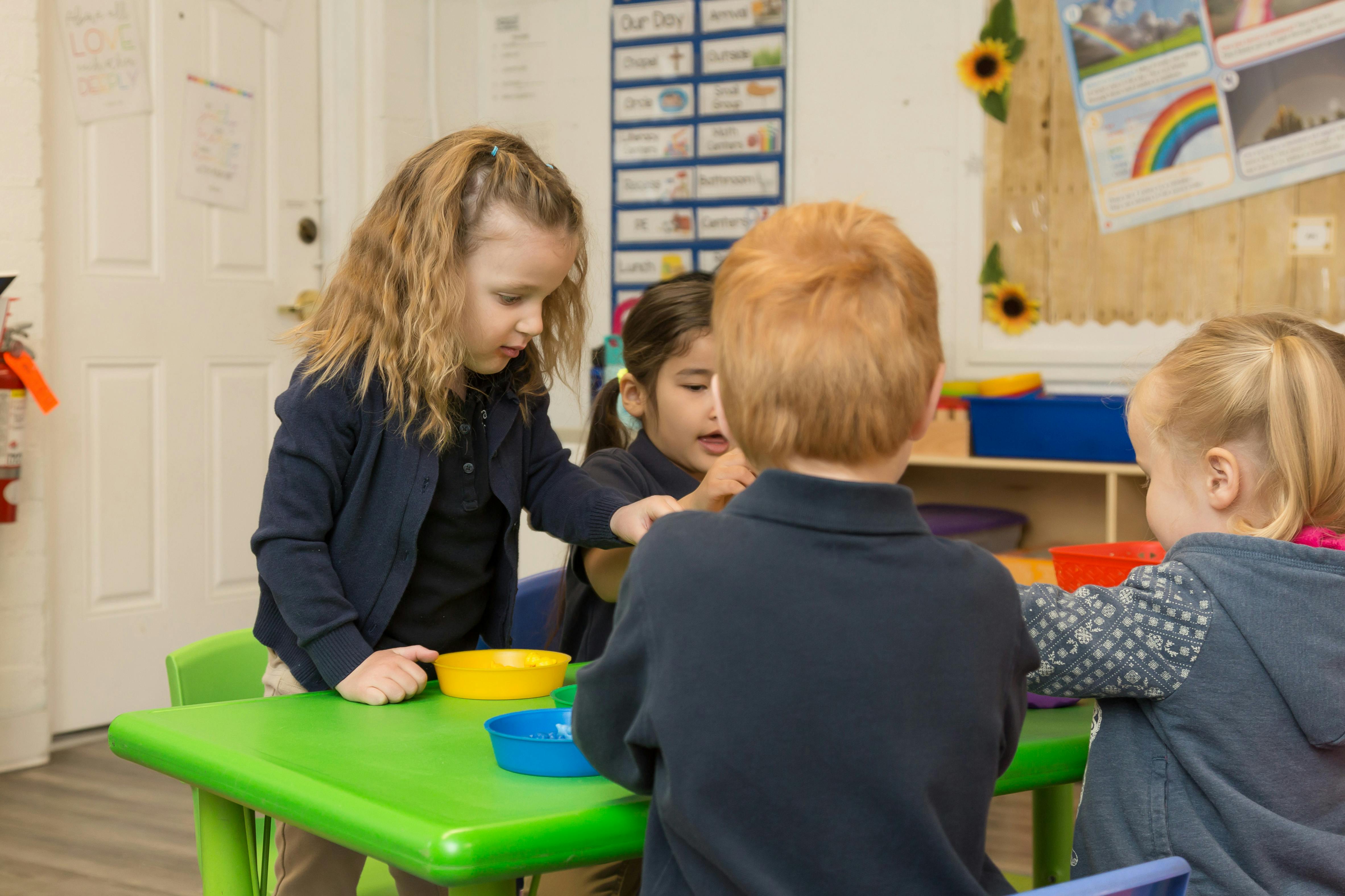 Children at a table with bowls in a classroom