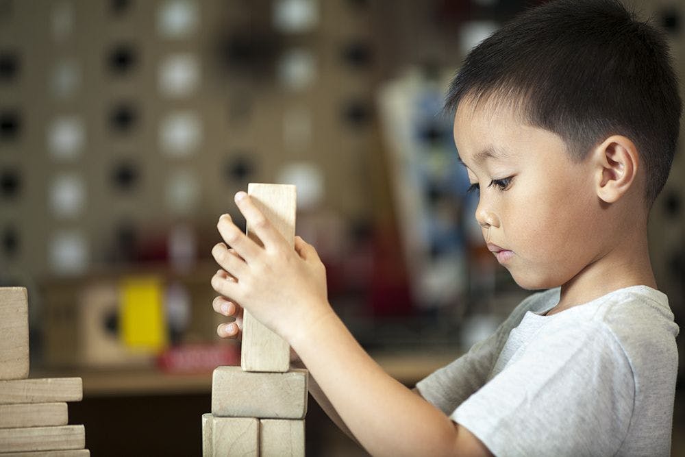 Child stacking wooden blocks