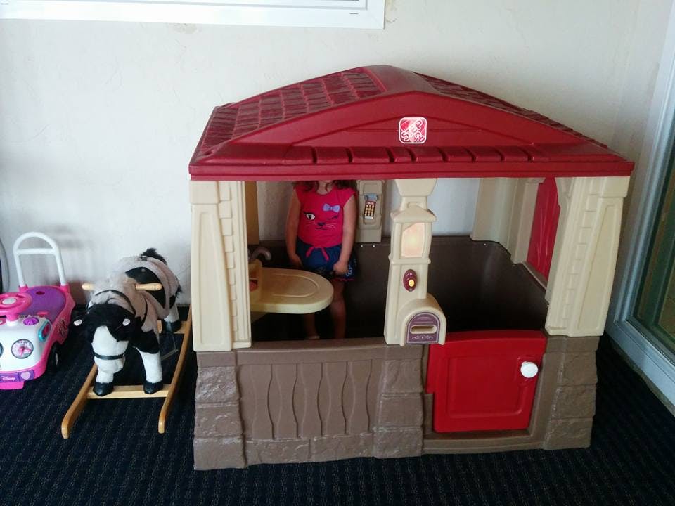 Child standing inside a playhouse