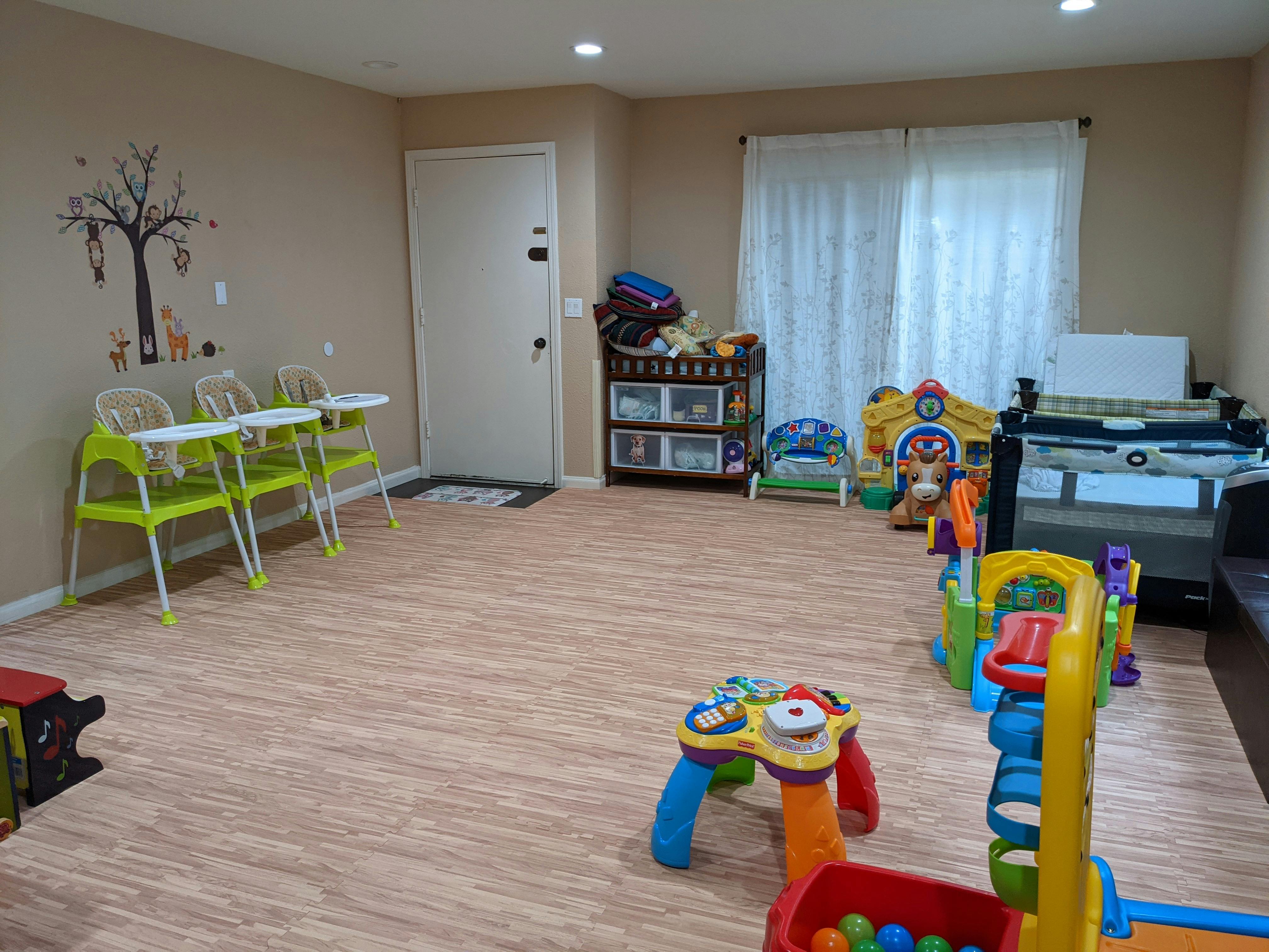 Room with high chairs, crib, and colorful children's toys
