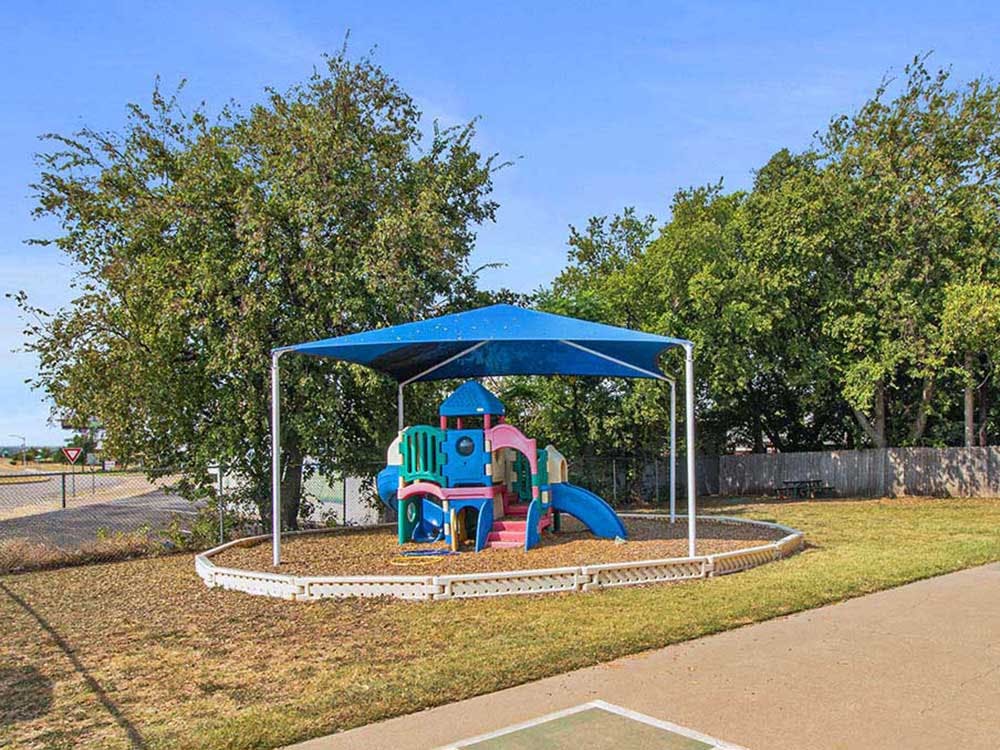 Colorful playground structure with a blue shade covering