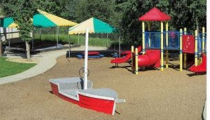 Playground with slides, tunnels, and a boat-frame shade structures