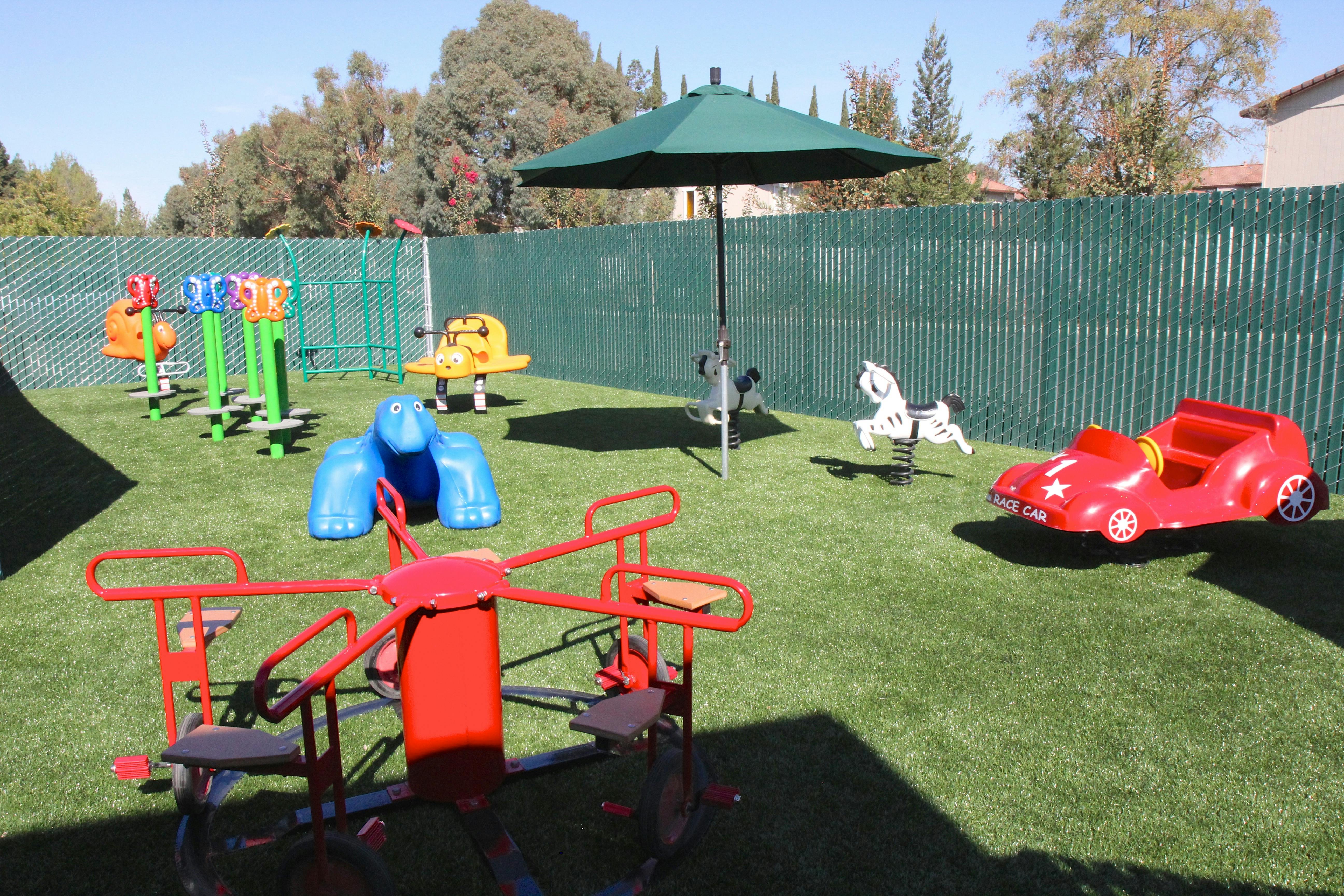 Playground with various colorful play equipment on artificial grass