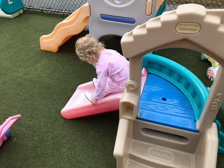 Child on a pink slide on a playground