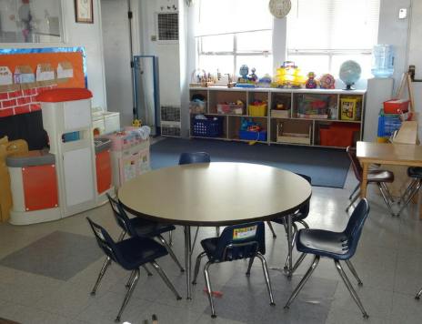 Classroom with a round table and chairs in the foreground