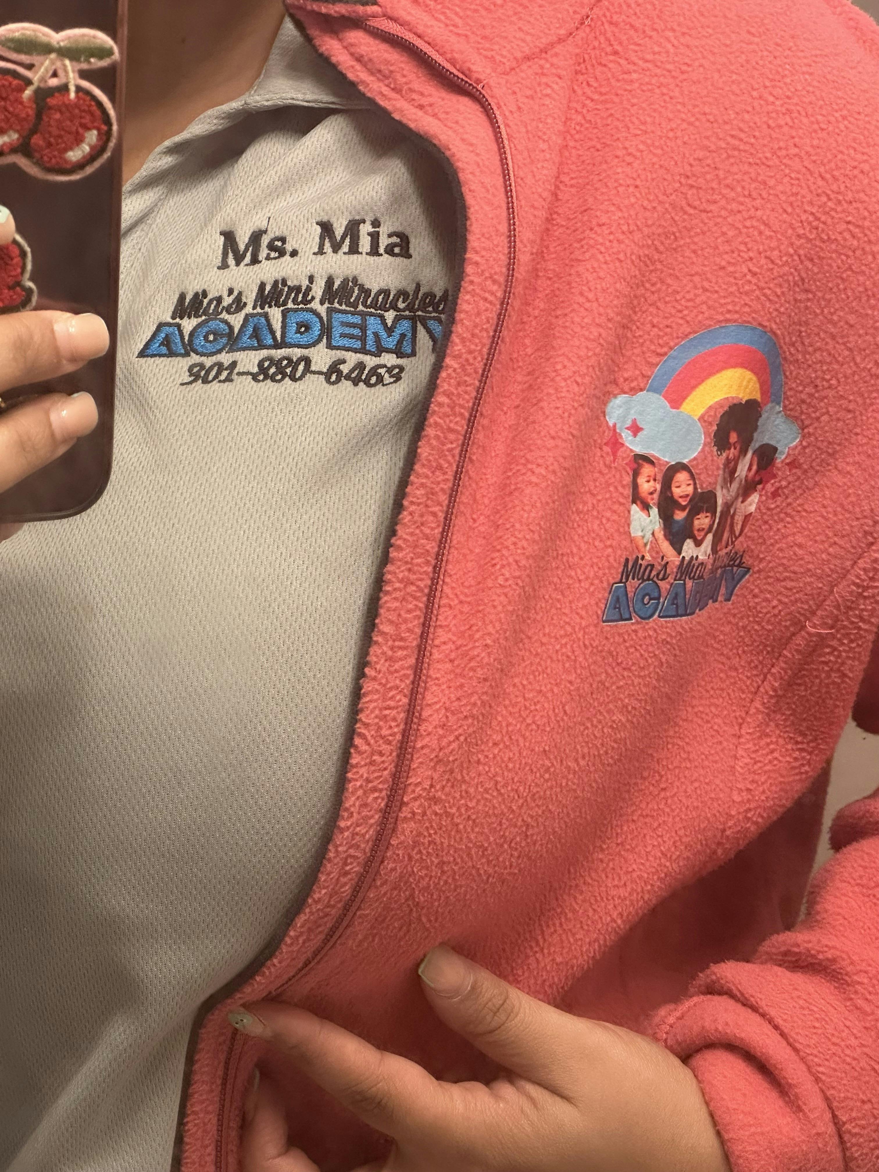 Person wearing a gray shirt with "Ms. Mia Mia's Mini Miracles Academy" text