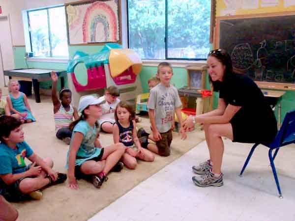 Adult speaking to a group of children in a classroom