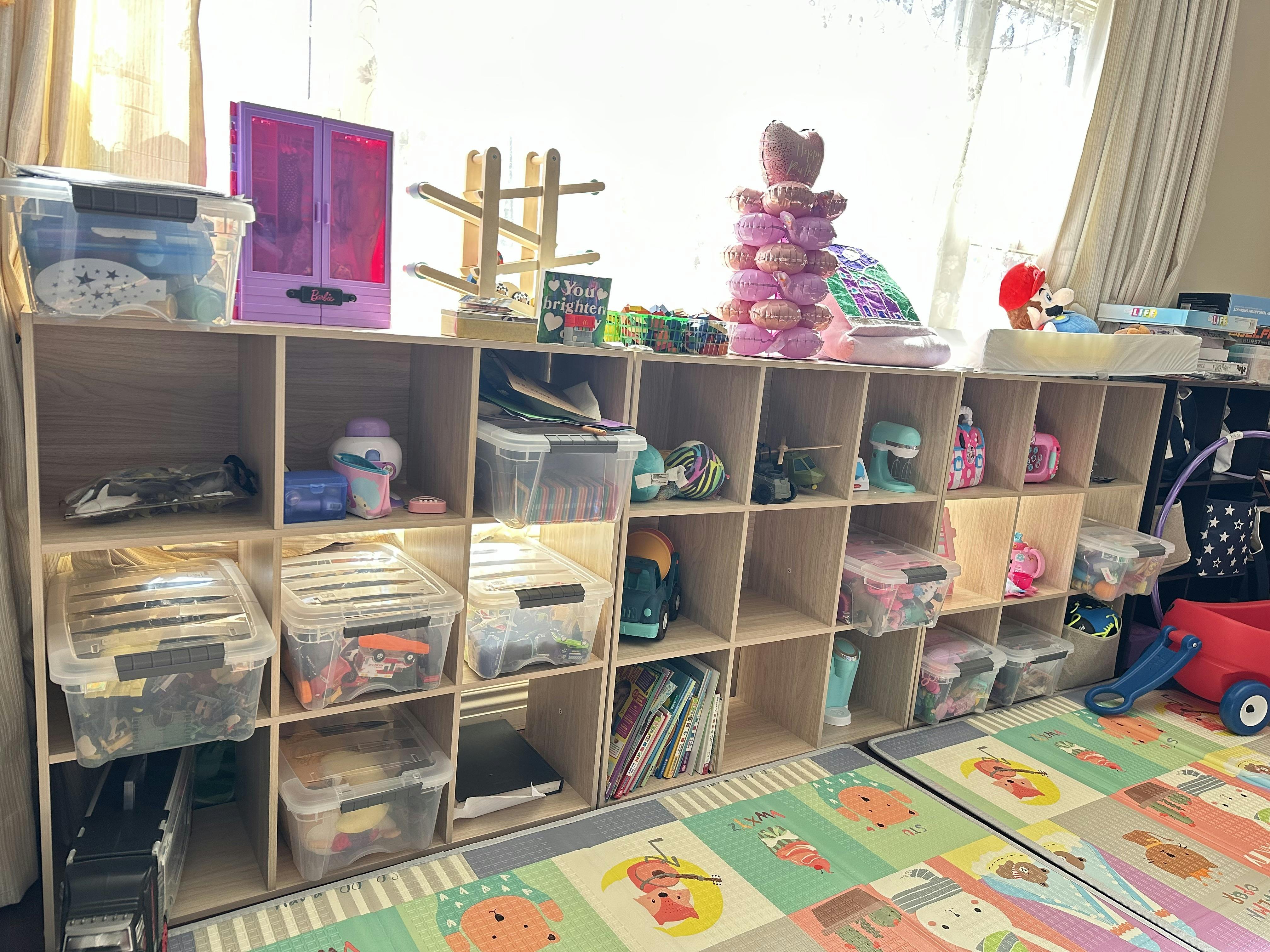 Wooden shelving unit filled with various toys and storage containers in a room