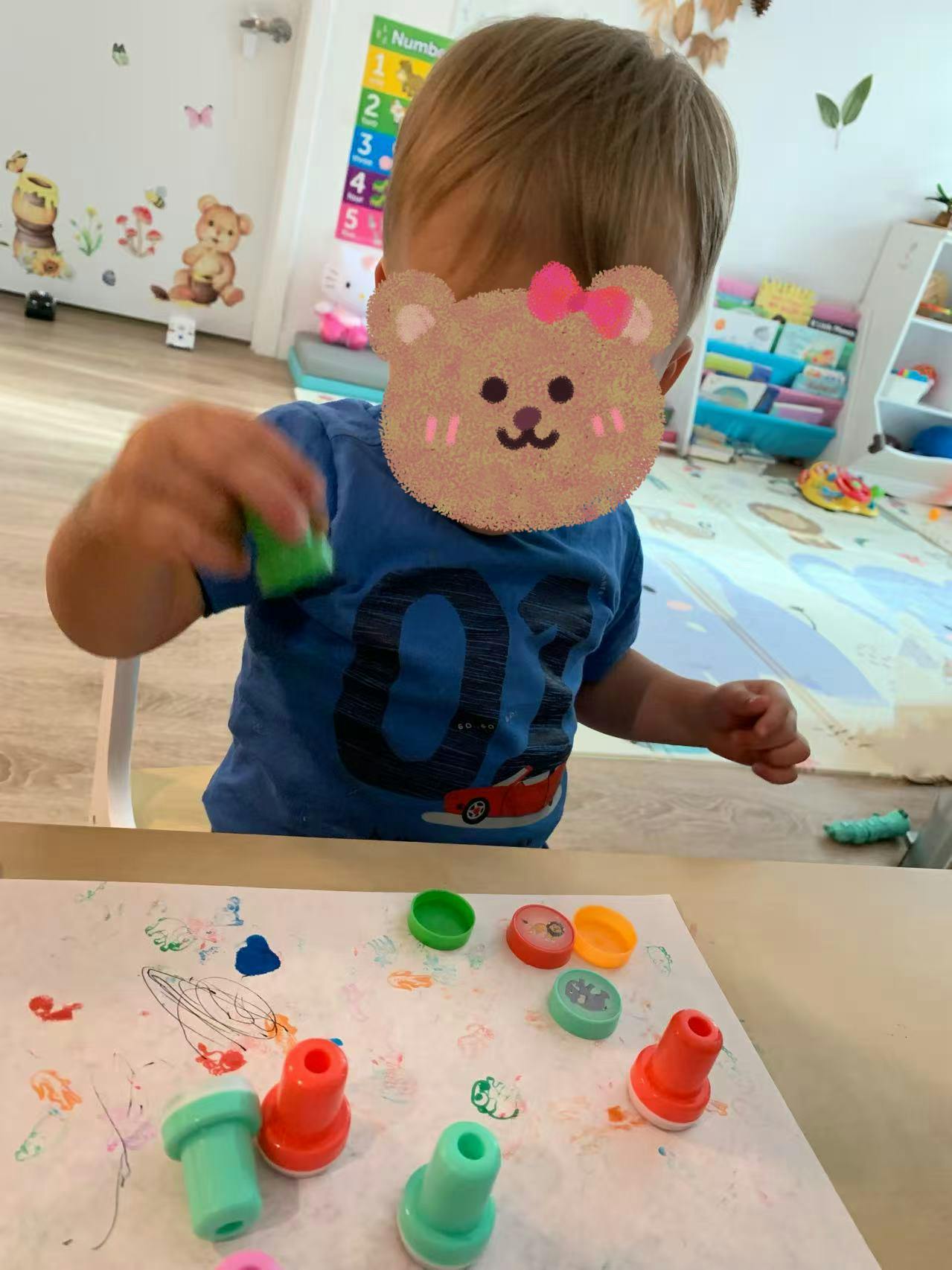Child playing with colorful stamps on paper
