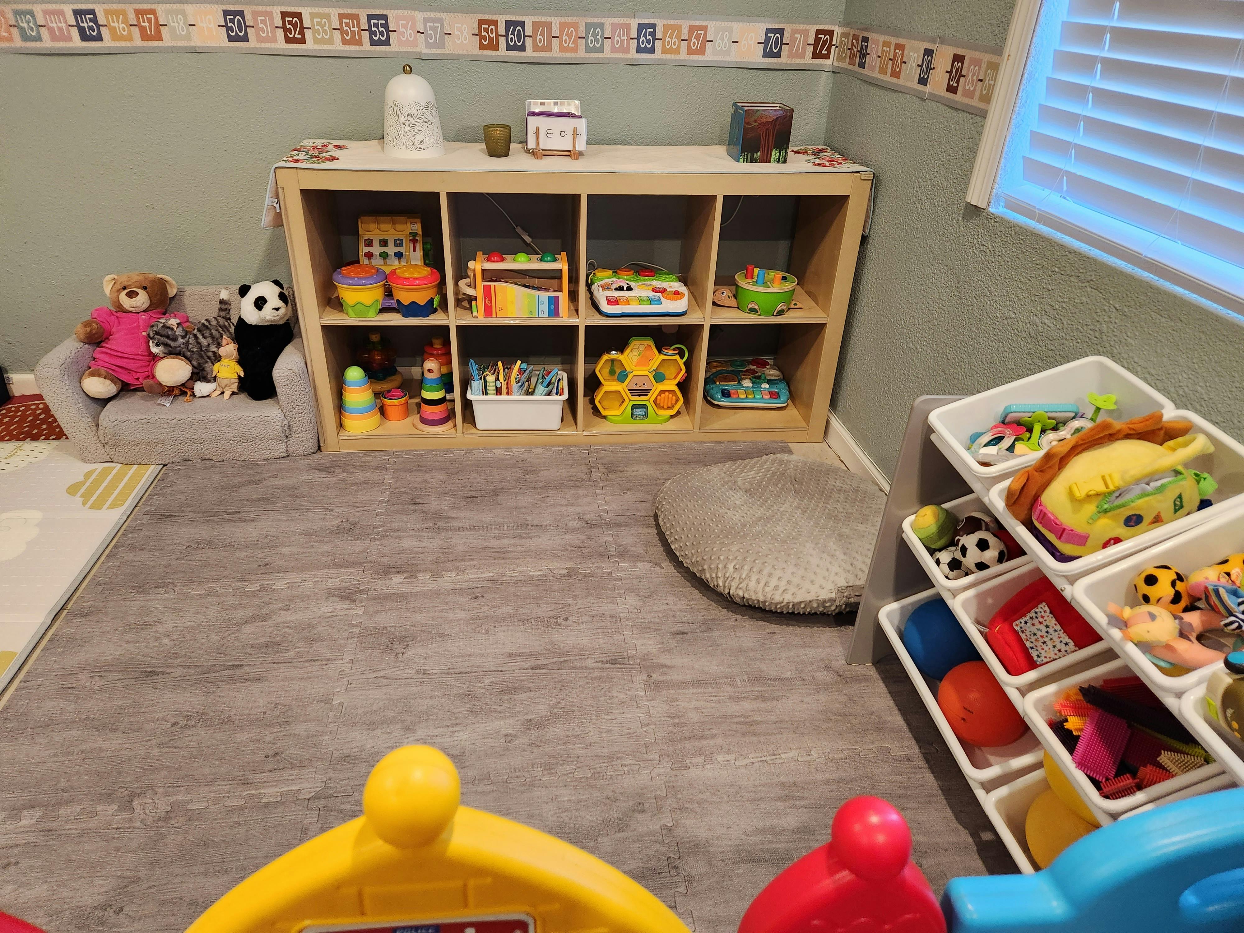 Playroom with toy storage shelves and bins filled bins