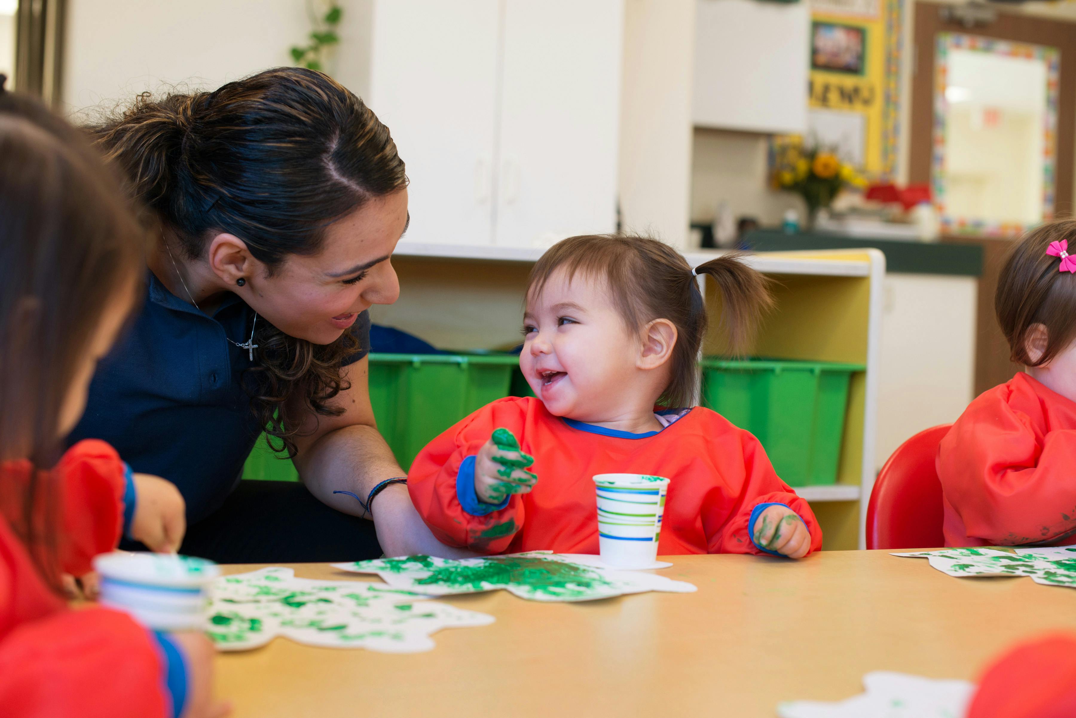 Adult and child finger painting at a table