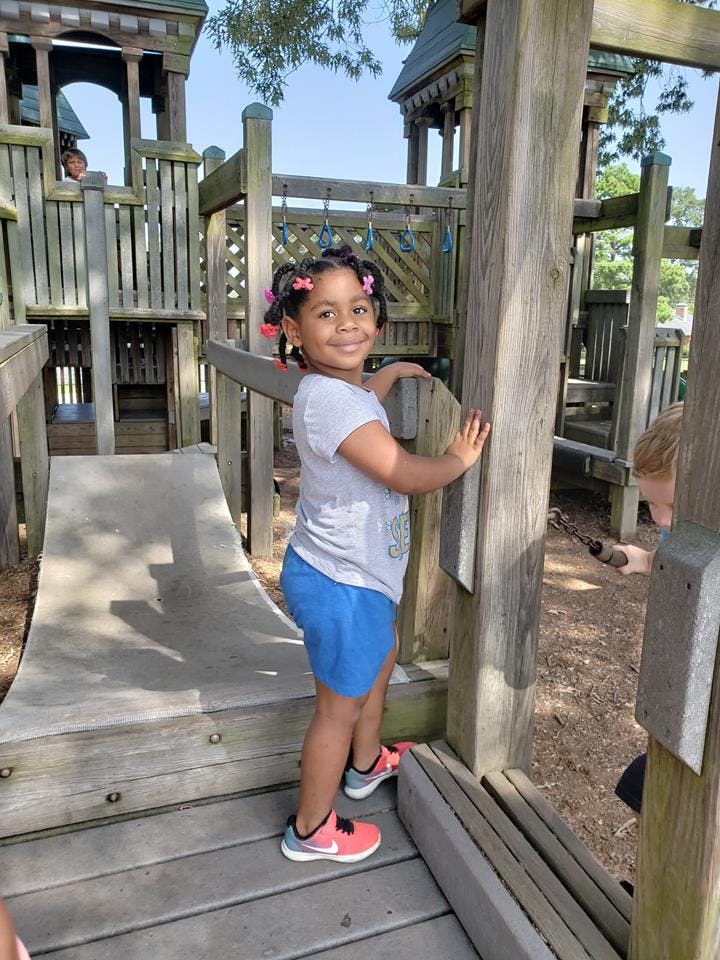 Child standing on a wooden playground structure
