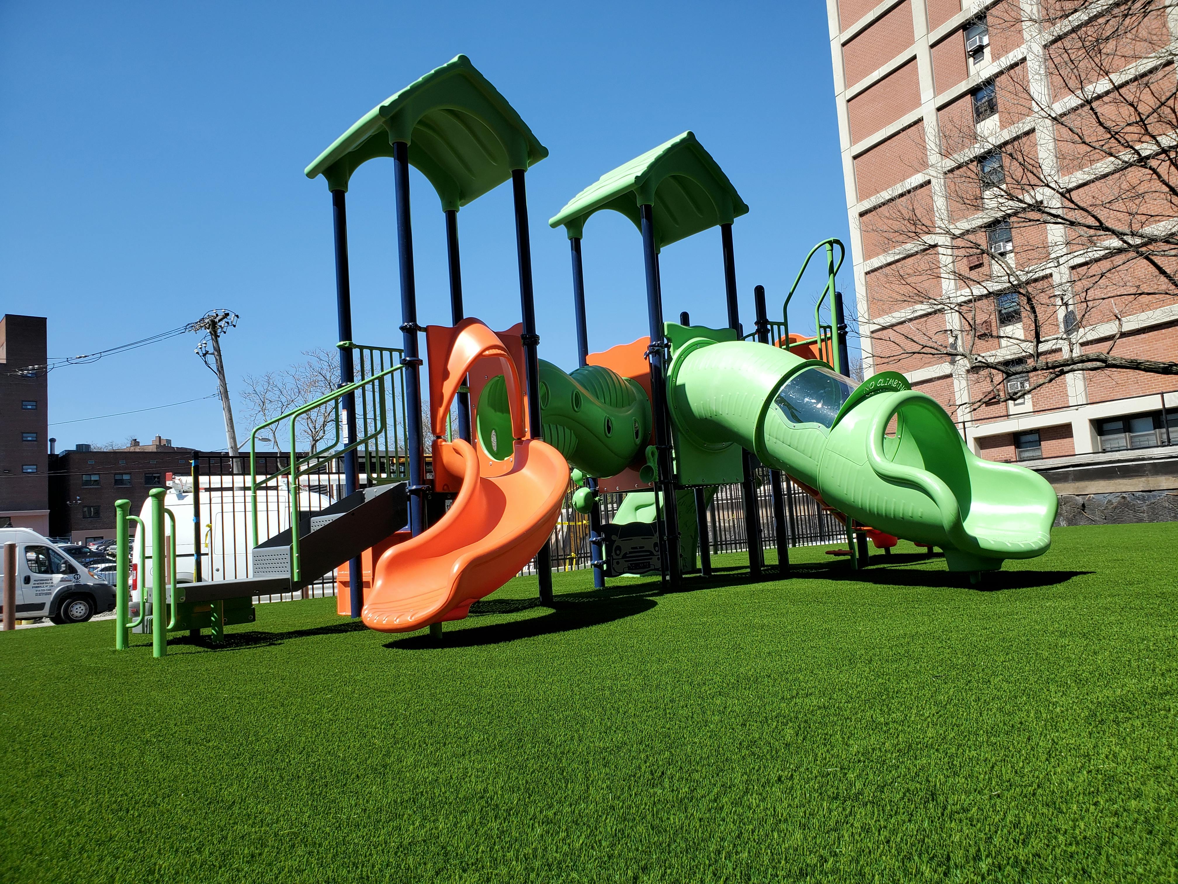 Playground with slides and climbing structures on artificial turf
