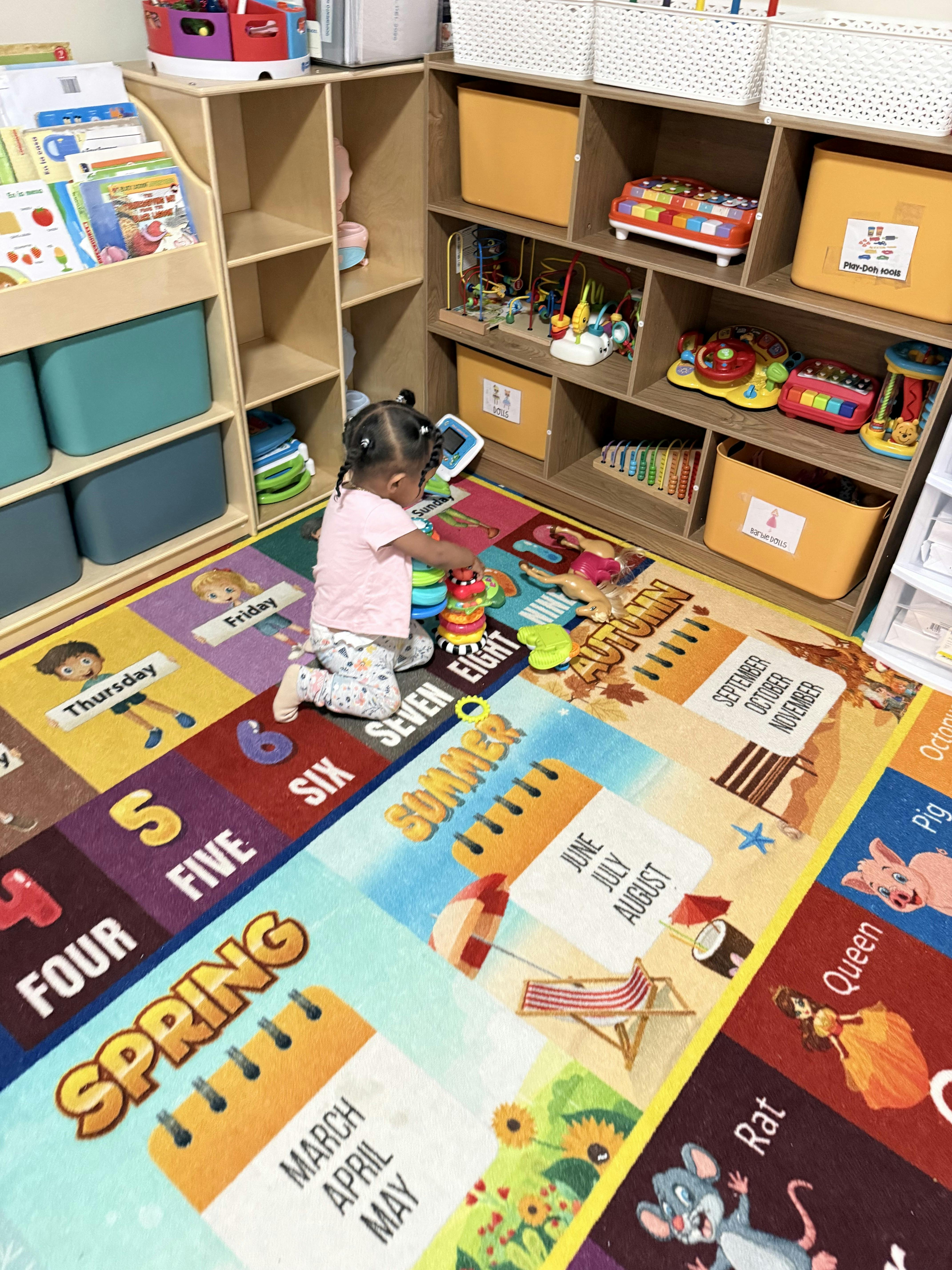 Child kneeling on a colorful rug and playing with stacking toys