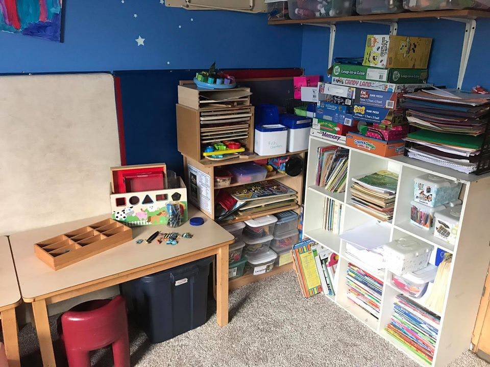 Classroom with tables, shelves, and storage bins