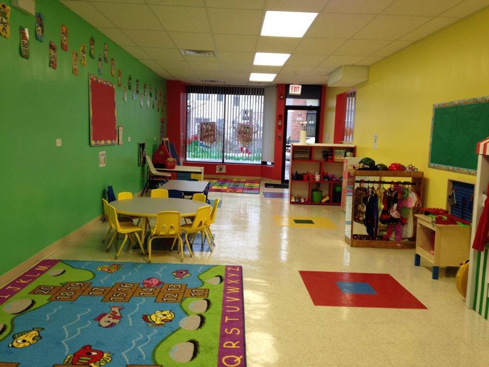 Colorful classroom with small tables and chairs, rugs, and storage units
