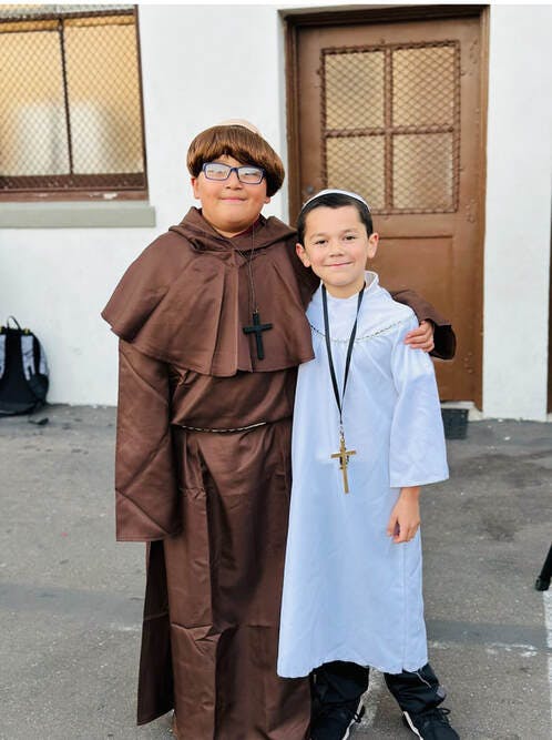 Two children in religious costumes with crosses