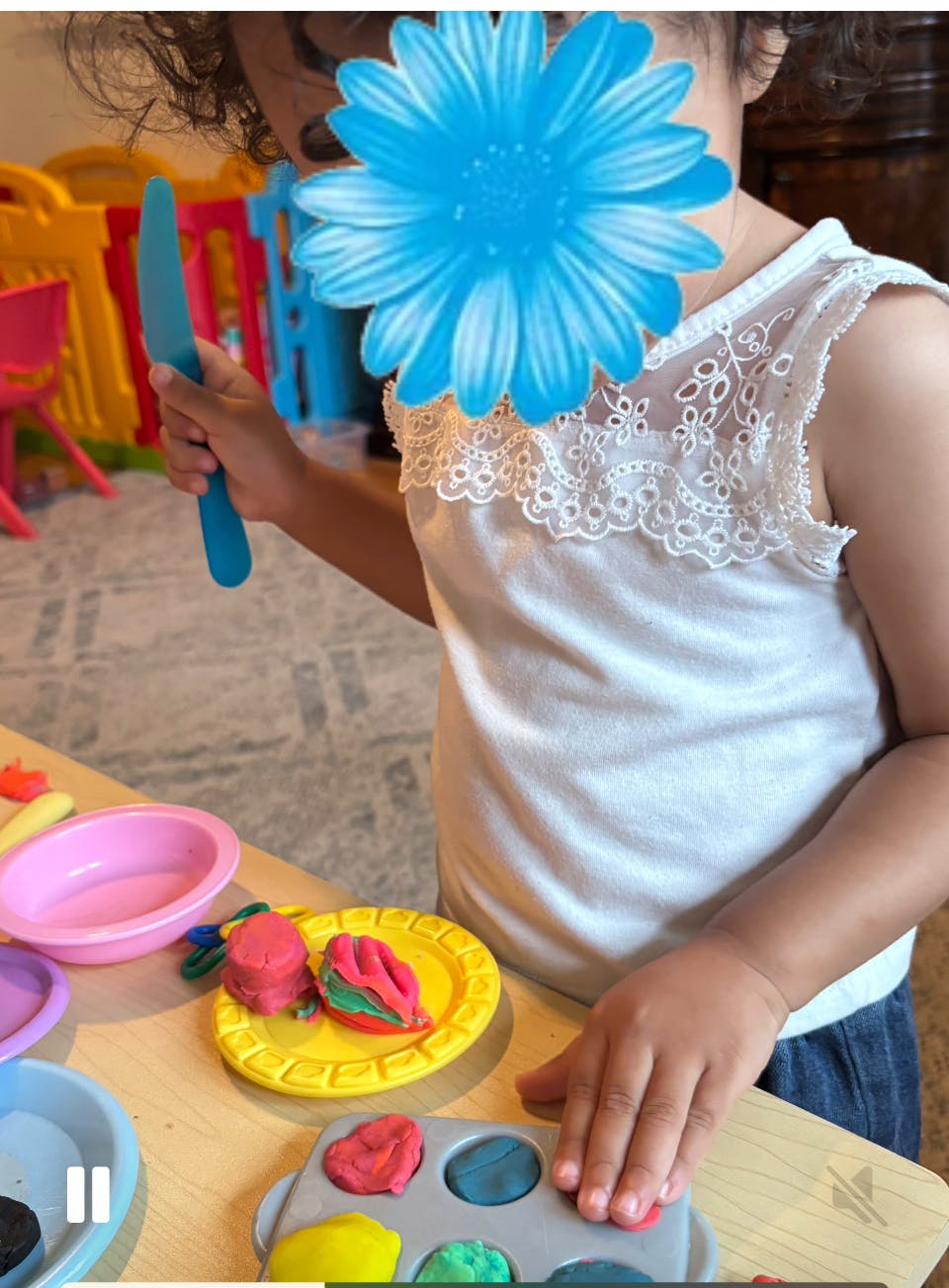 Child playing with colorful modeling clay at a table