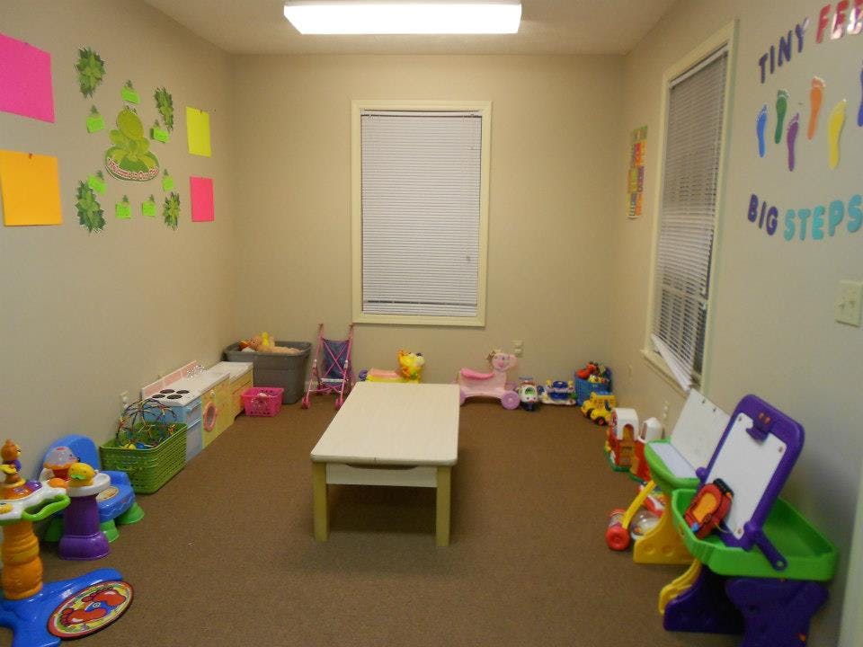 Playroom with small table, toys, and wall decorations