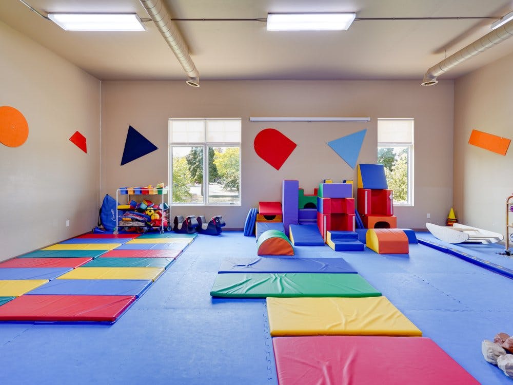 Colorful playroom with soft mats on the floor and large foam play structures