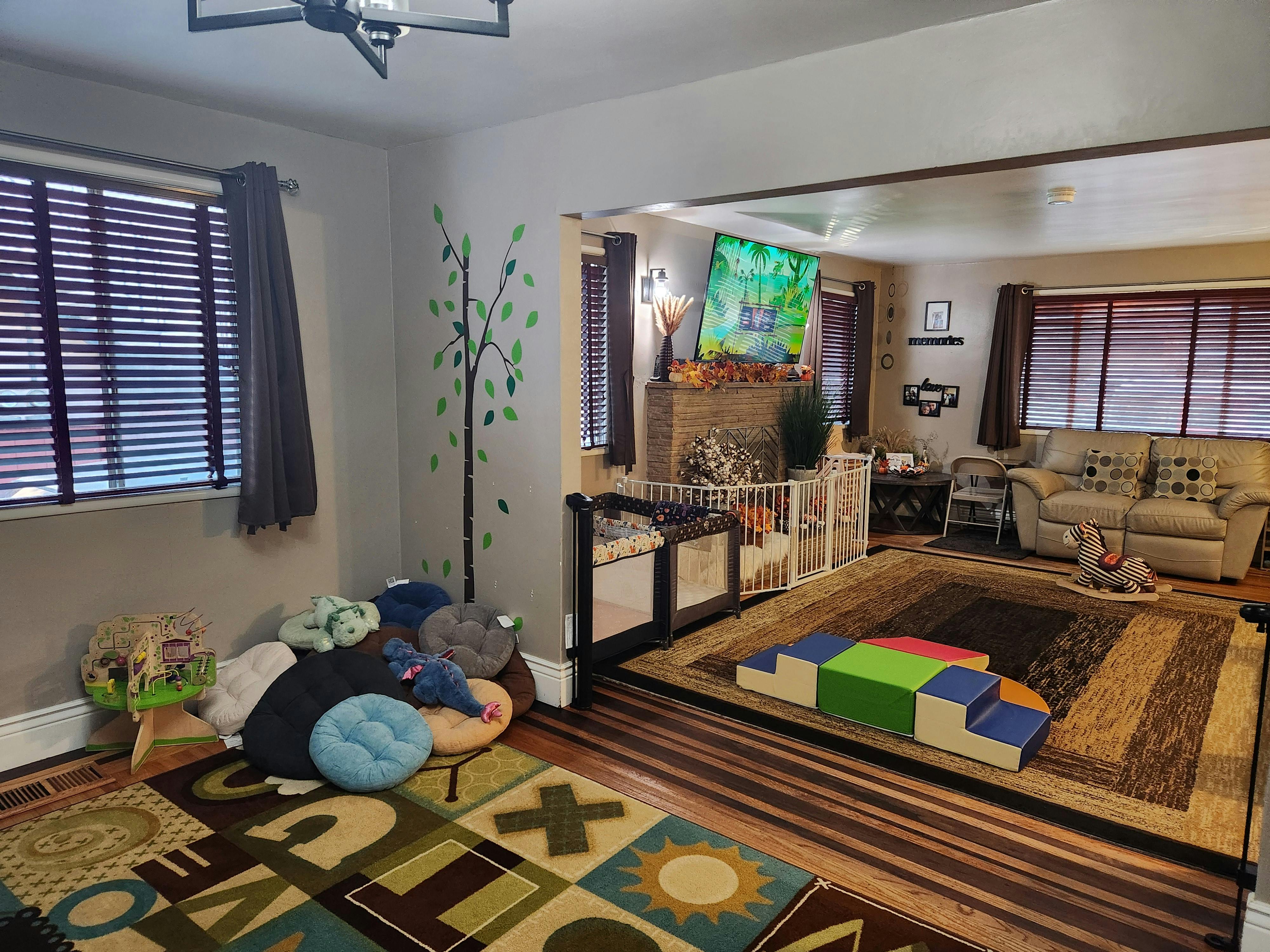 Living room with play area, cribs, and sofa