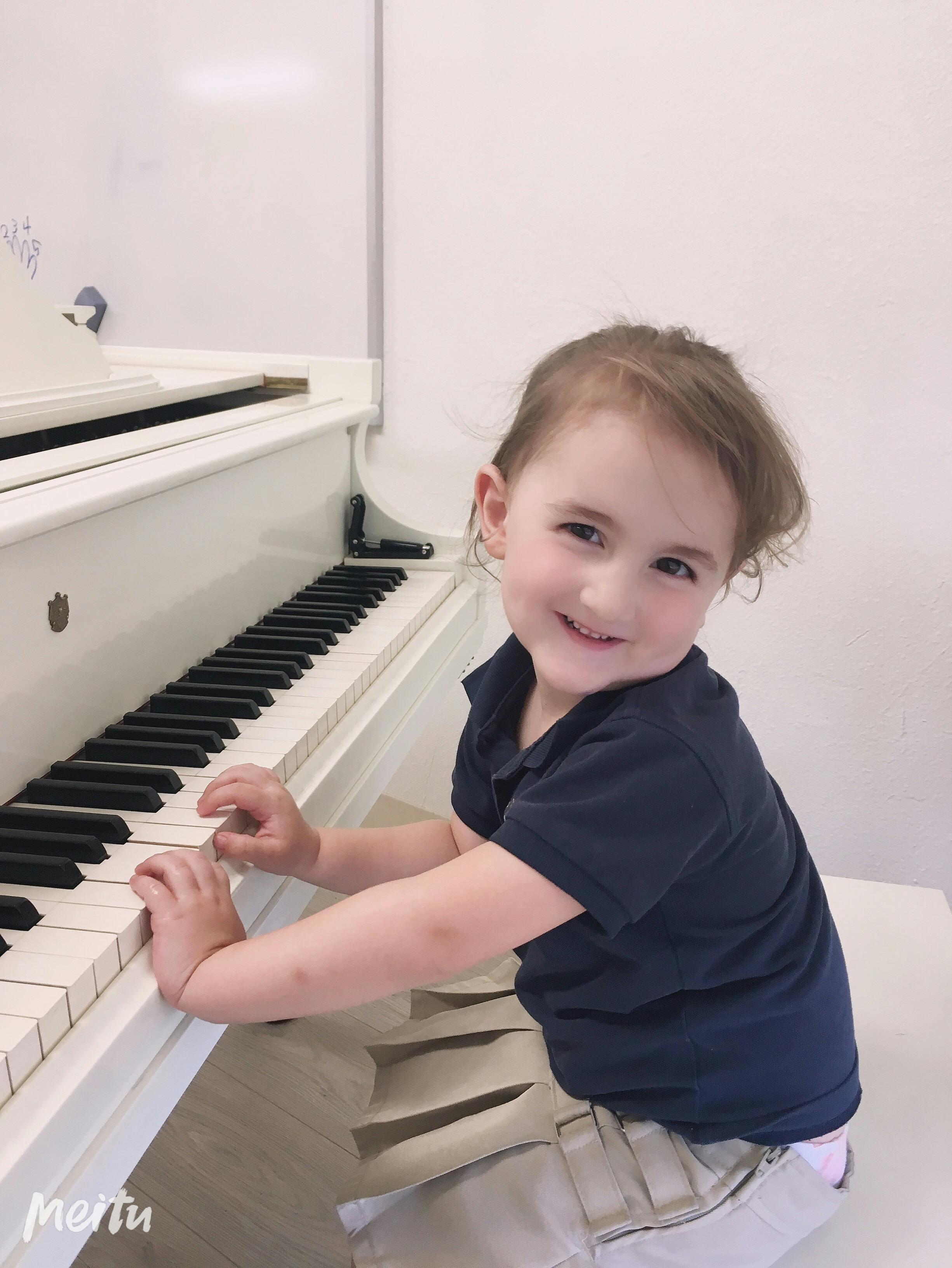Child playing a white piano