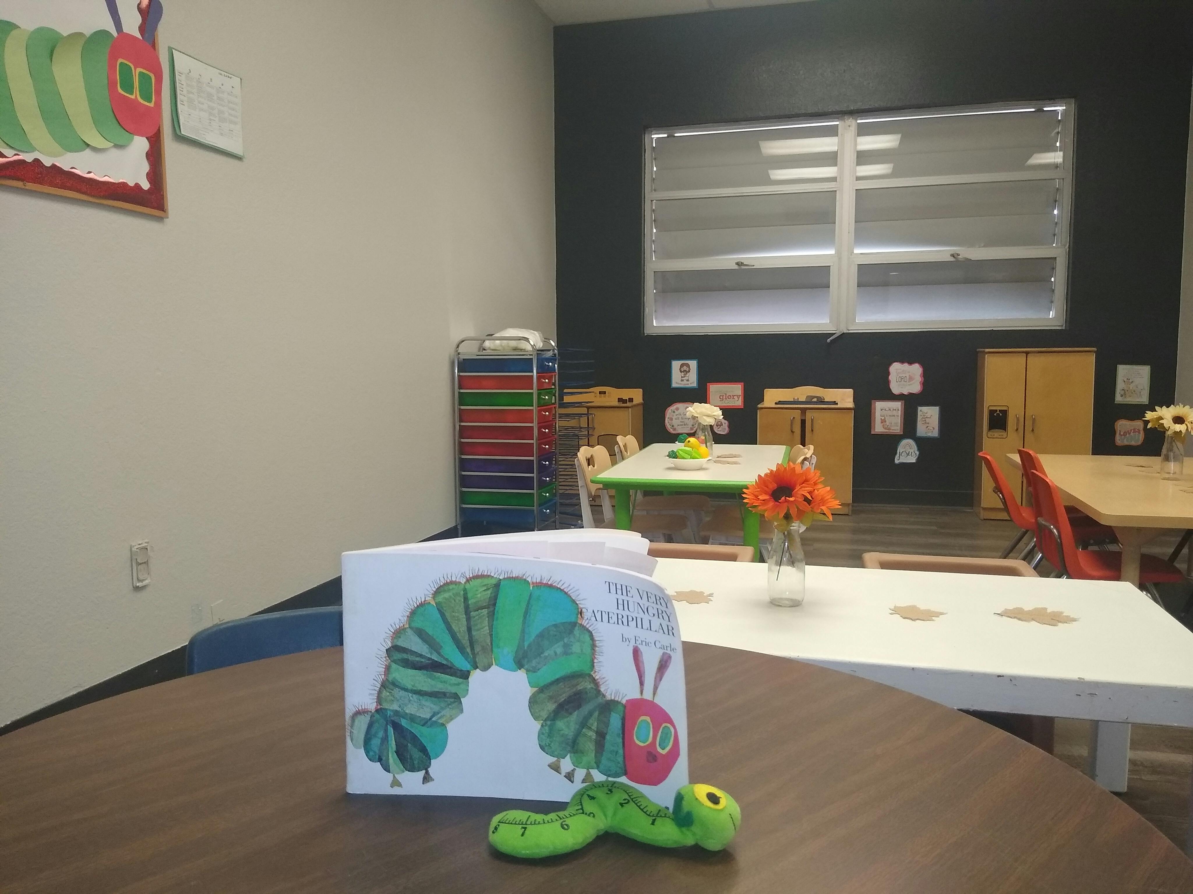 The Very Hungry Caterpillar book and toy on a table in a classroom
