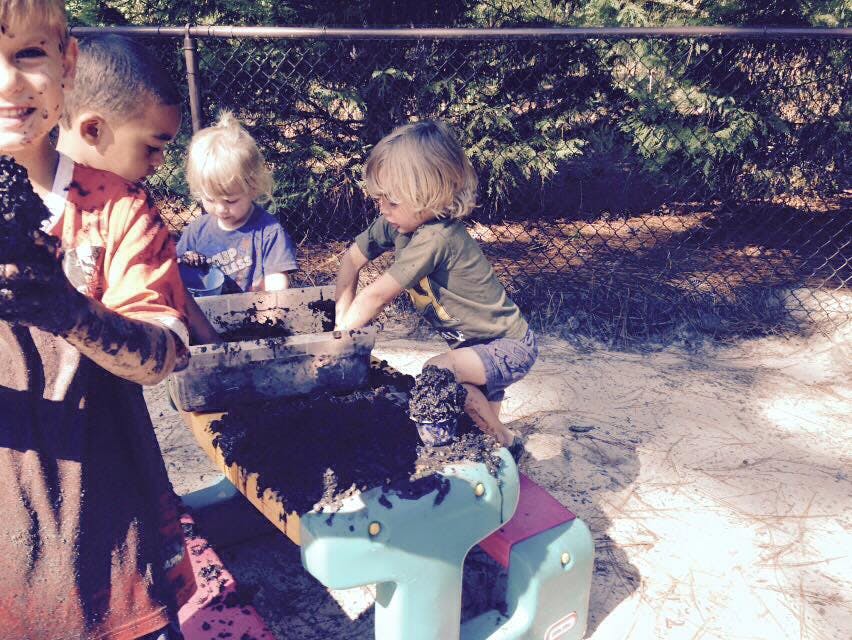 Children playing in mud at a mud kitchen
