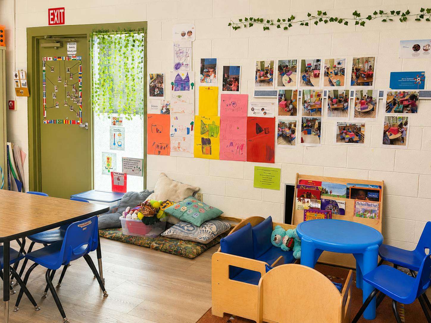 Classroom interior with children's artwork and photos displayed on a wall