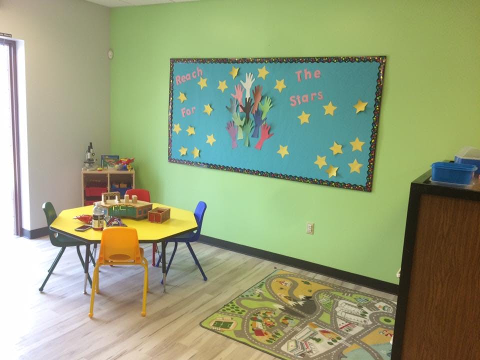 Classroom with a yellow hexagonal table and a bulletin board with stars