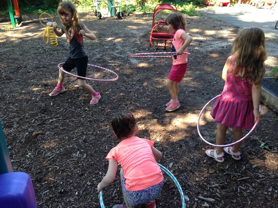 Children playing with hula hoops outdoors