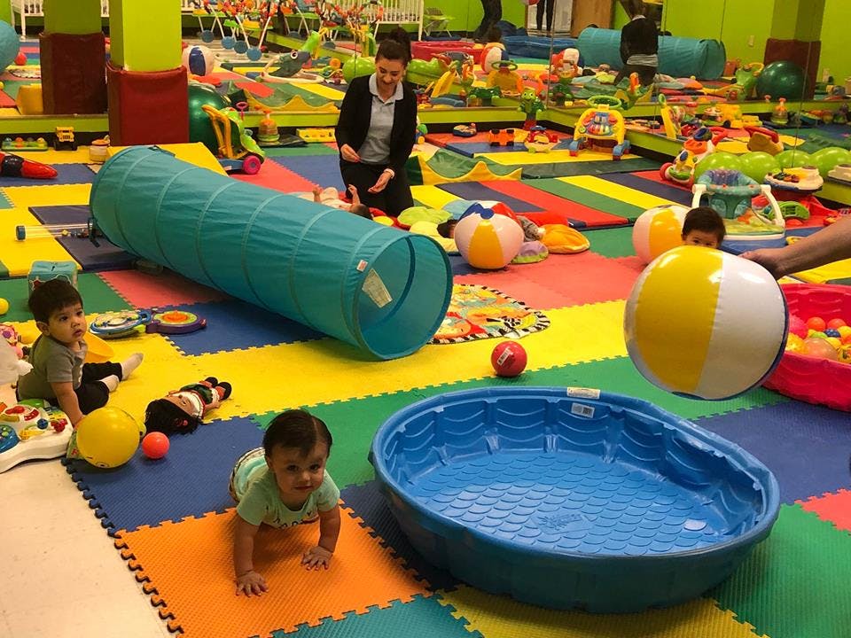 Adult and children playing with toys in a colorful room