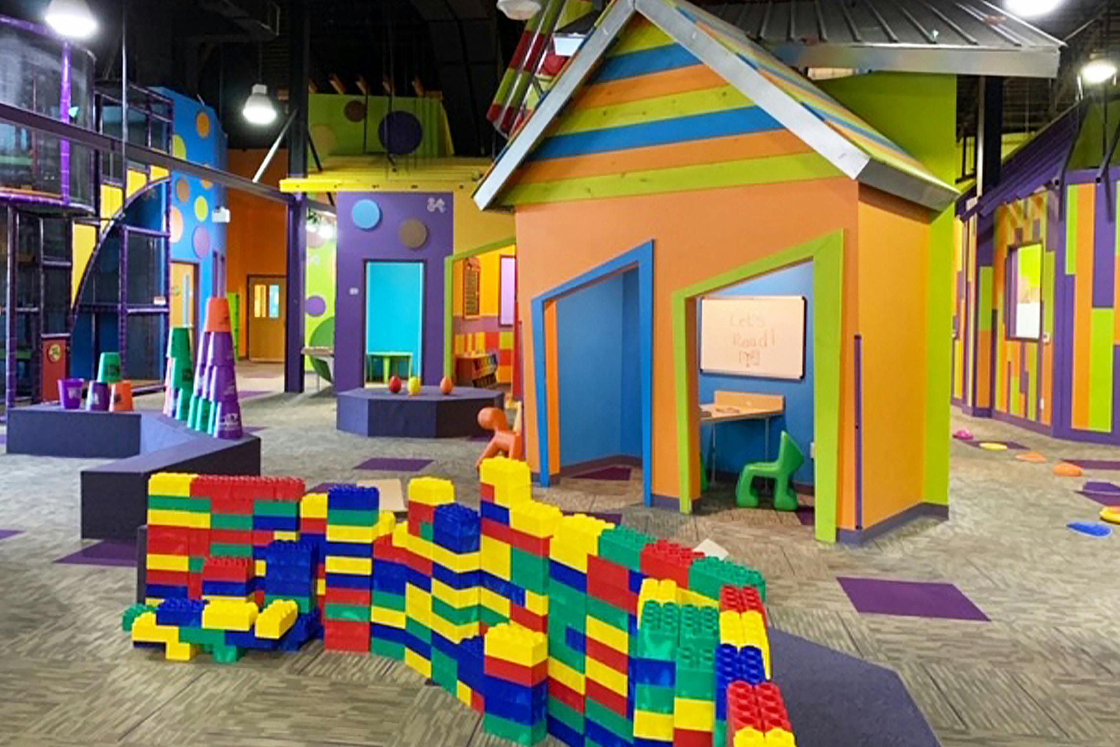Colorful indoor play area with miniature houses and large building blocks