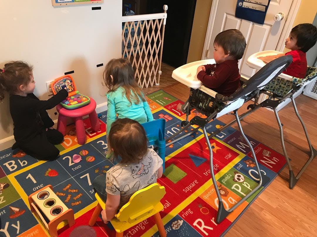 Children playing on a colorful alphabet rug