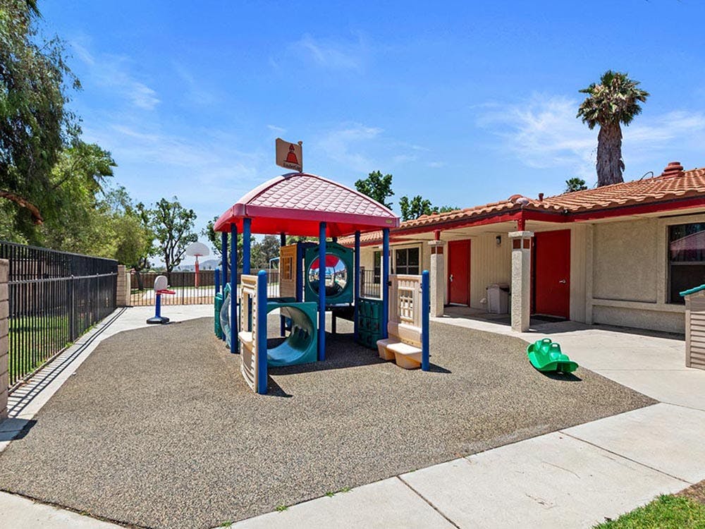 Outdoor playground with play structure and small basketball hoop