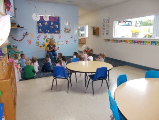 Adult reading to children in a classroom