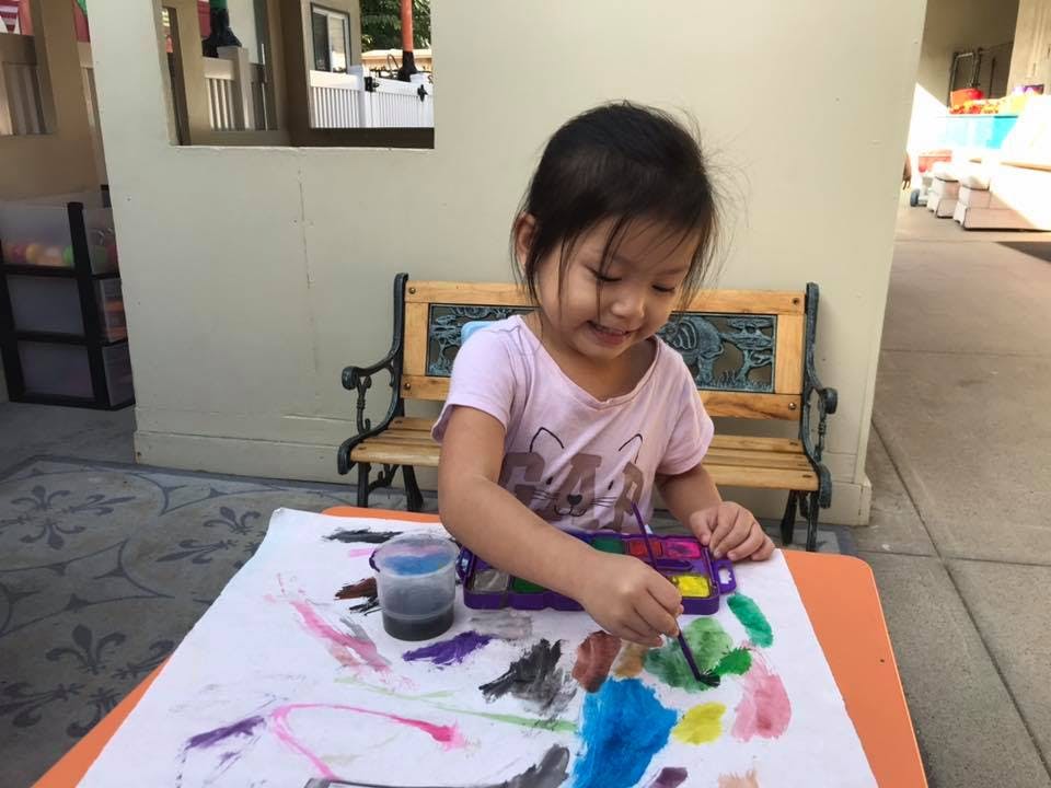 Child painting on paper at a table