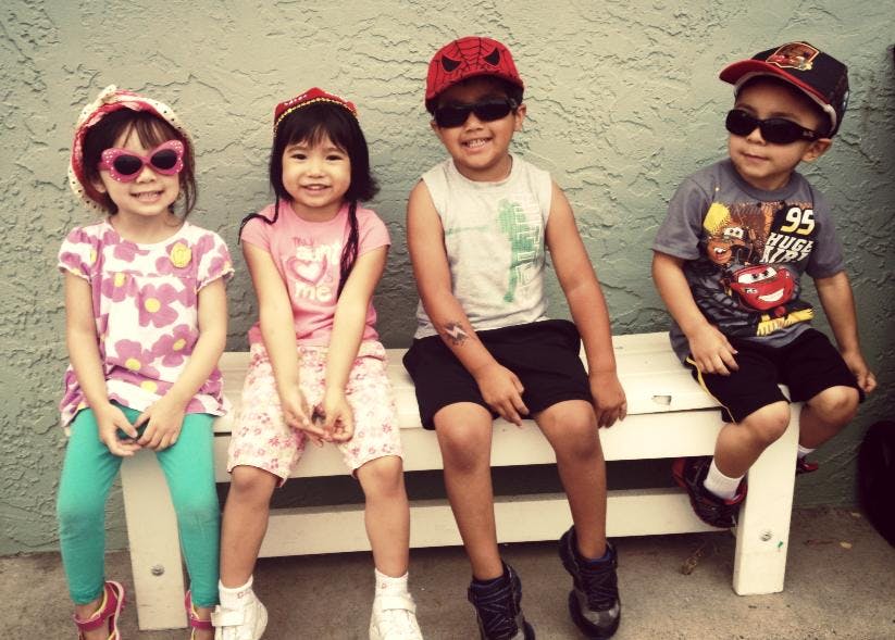 Four children sitting on a bench