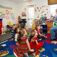 Adult reading to children in a classroom