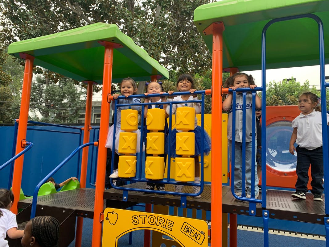 Several children playing on a colorful playground structure