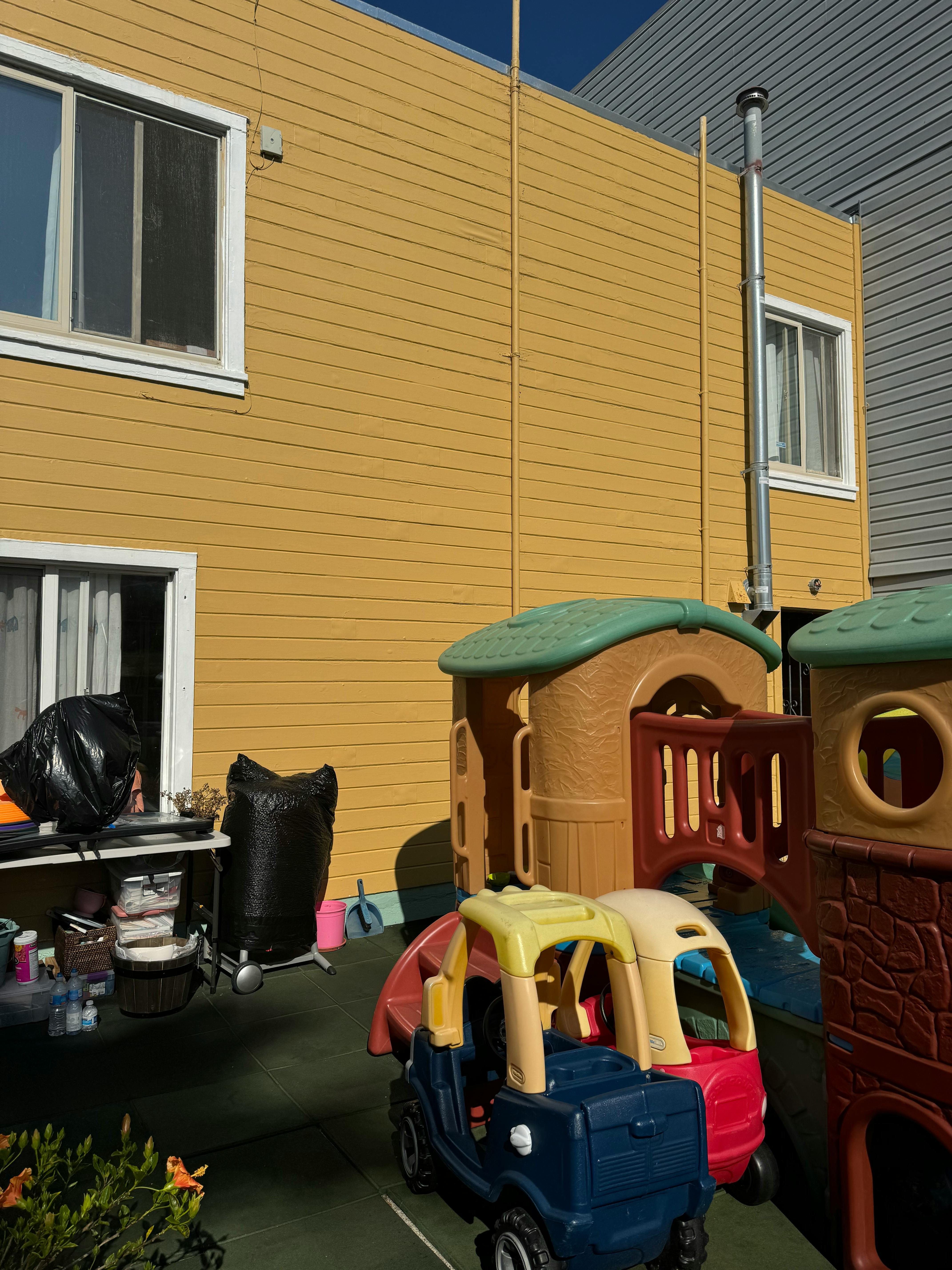 Play structures and toy cars in front of a building
