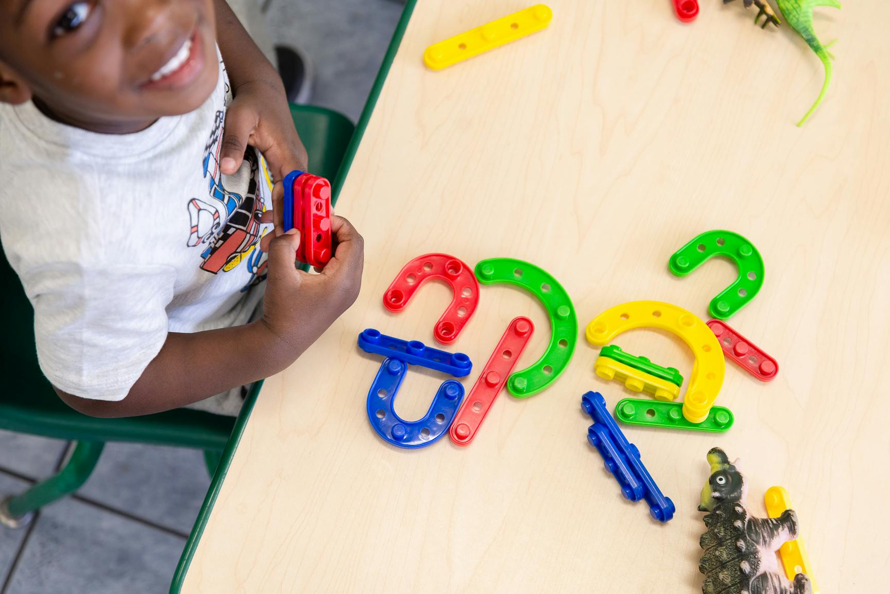 Child playing with colorful building blocks on a table